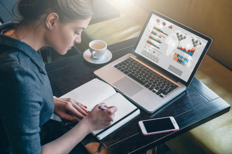 Side,view.,young,business,woman,sitting,at,table,and,taking